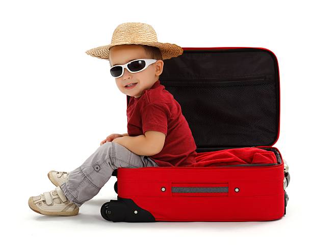 istock Confident little boy wearing straw hat, sitting in suitcase 157991302