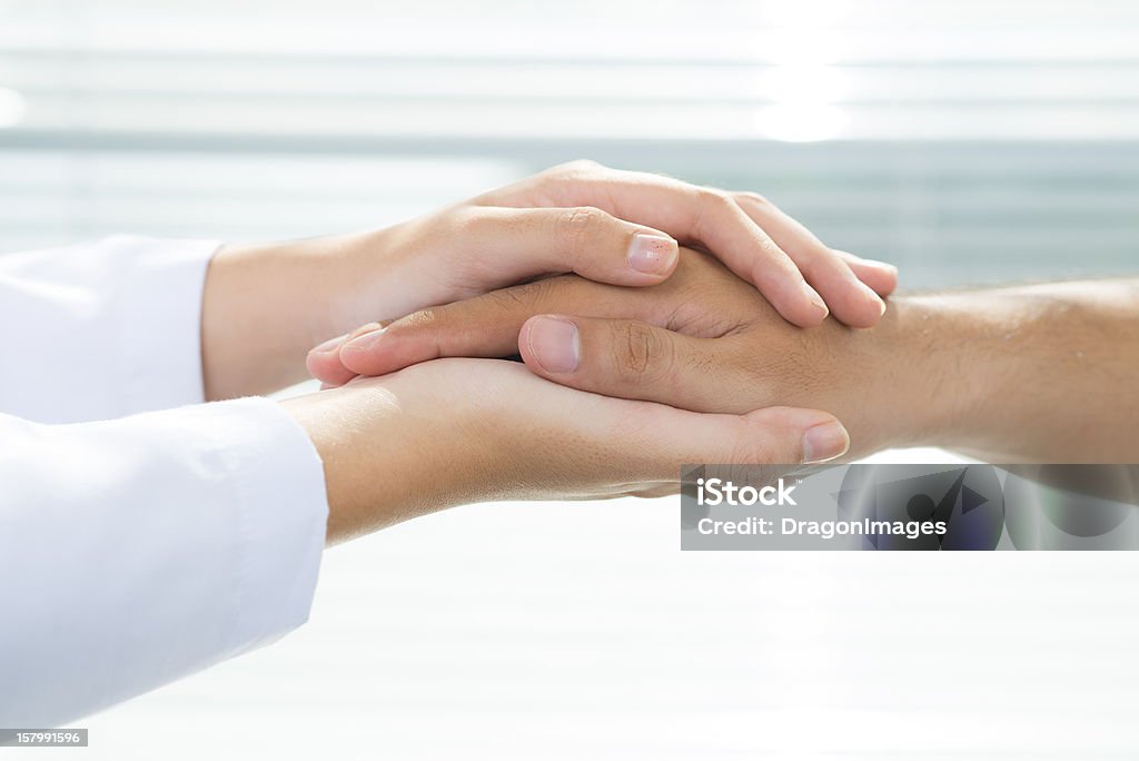 Support Two people holding hands for comfort Doctor Stock Photo