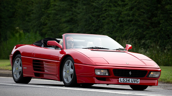 Bicester,Oxon,UK - June 19th 2022. Red 1994 Ferrari 348 car driving on an English country road