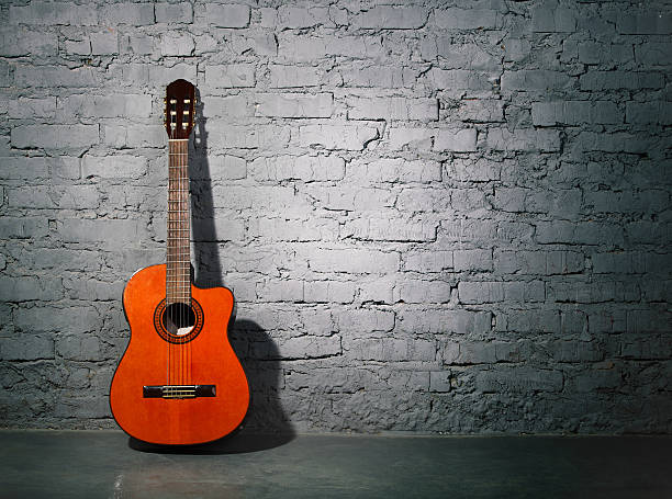 istock Acoustic guitar leaning on grungy wall 157992540