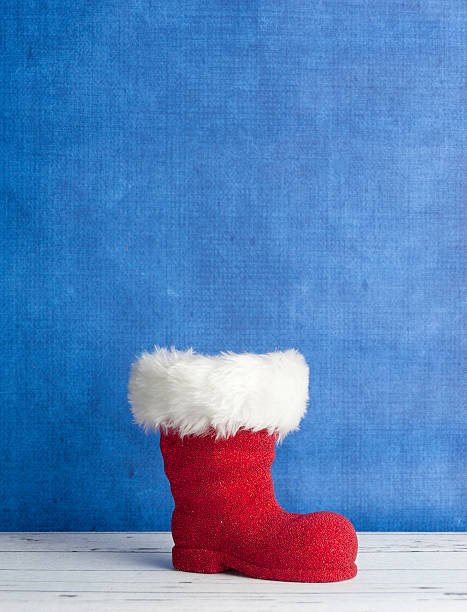 rot santa boot auf einem blauen hintergrund - nikolaus stiefel stock-fotos und bilder