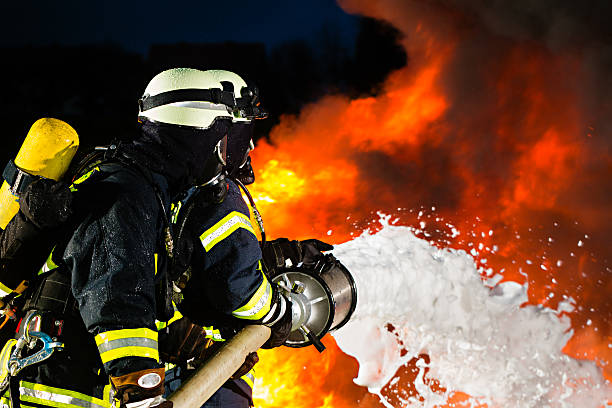 i vigili del fuoco pompiere di estinzione di un grande vampata - vigile del fuoco foto e immagini stock