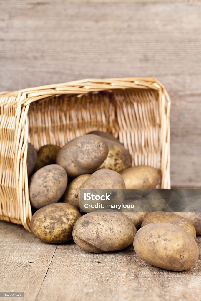 basket with fresh potatoes basket with fresh potatoes on rustic wooden background Agriculture Stock Photo