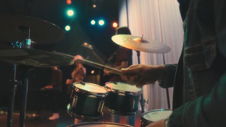 close up Asian Chinese Drummer jamming session with Multiracial group live band performance on stage