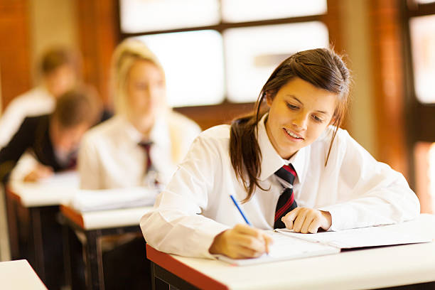 Reading the information that is in the notepad. Pupils, kids in the classroom together.