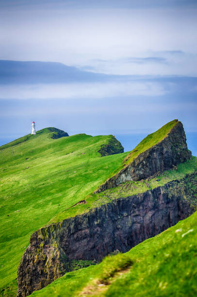 Far looking to Iconic red and white lighthouse on Mykines Island