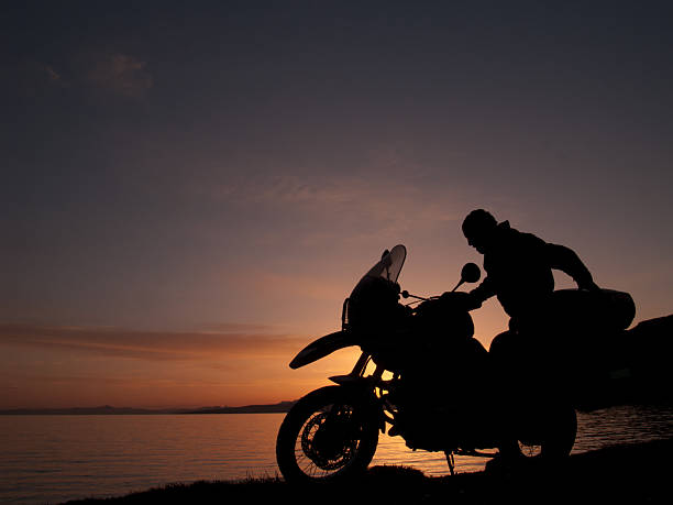 Cтоковое фото Силуэт наездника мотоцикла на закате ближе снимок