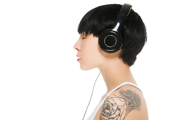 美しい少女の音楽をお楽しみになりながら、目を閉じた - headphones women tattoo music ストックフォトと画像