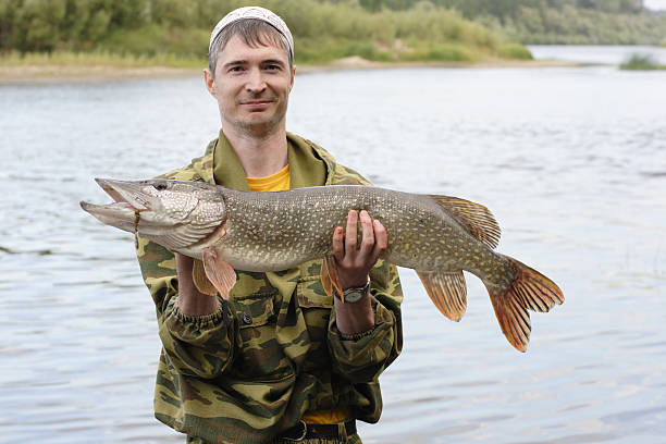 istock Young angler holds and showing big pike 158001858