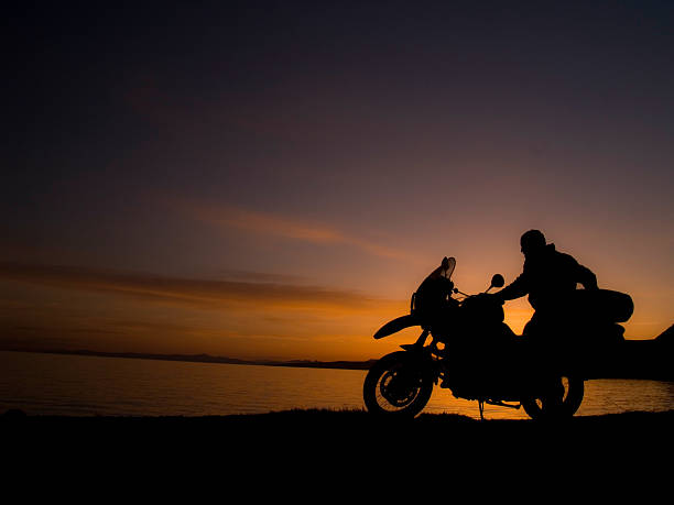 Motocicleta Rider silhueta no pôr-do-sol - foto de acervo