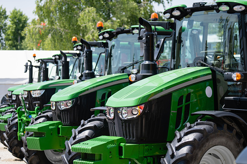 A row of green agricultural tractors.