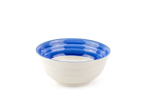 Front view empty white ceramic bowl with blue rim isolated on a white background. Use for home or restaurant, food design. Kitchen accessory.