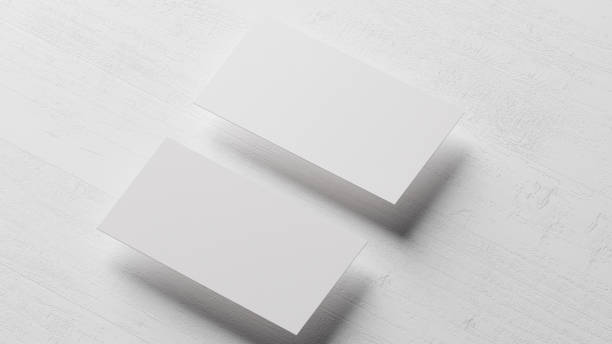 istock Two blank horizontal business cards mockup on white wood desk 1580133484