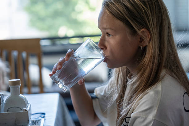 istock Girl drinking water at home. 1580138164