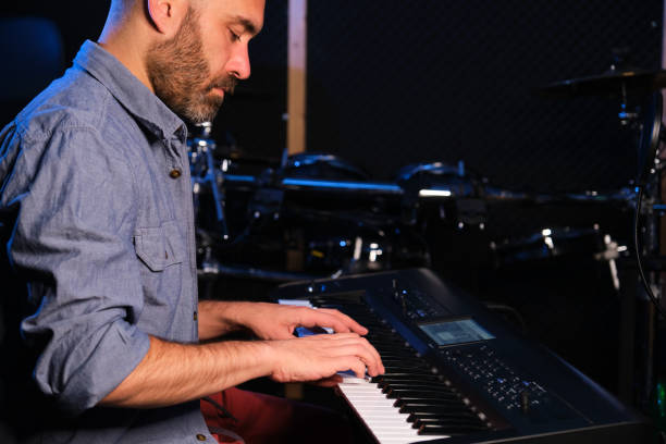 istock Musician man playing the electric piano in a recording studio. 1580141299