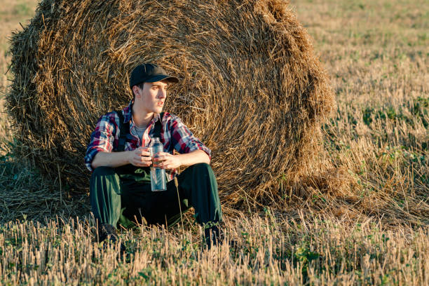 istock Exhausted farmer resting next to a straw bale 1580150246