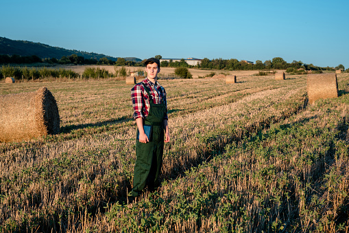 Portrait of a young male farmer standing in a wheat field