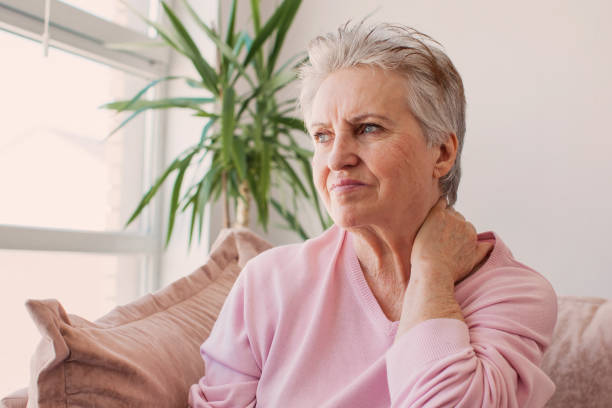 불행한 60 세 여성은 집에서 통증이있는 목이 있습니다. - 60 65 years 뉴스 사진 이미지