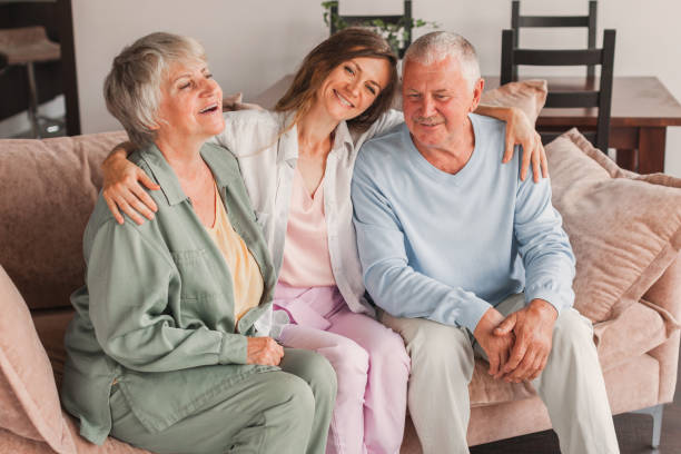 istock Defferent generation family hugging sit on sofa enjoy time together at home, laughing grown up daughter with dad and mom 1580164320