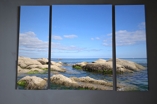View of Tropical Waters on a Sunny Day Through a Window of an Abandoned Building with Shutters Looking out to Paradise