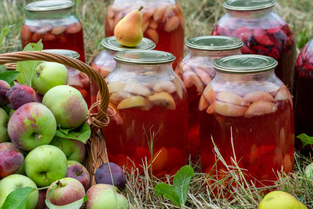 Jars of preserved fruit compote for the winter. Apples and pears in the basket.