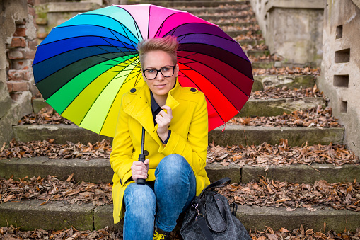 Pretty young smiling woman with colorful umbrella