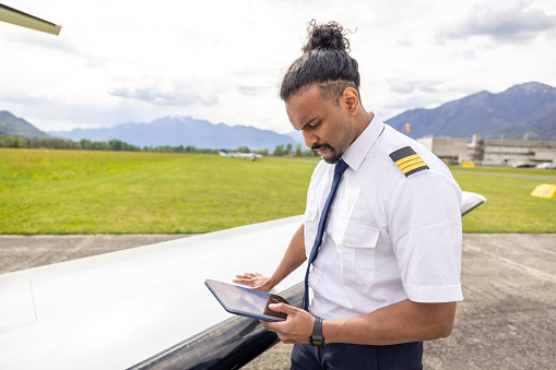 Male young pilot preparing private jet for flight