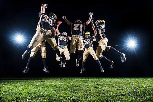 American Football Players celebrating their victory. Group of tough American football players celebrating their victory. They are jumping on the playing field.   http://dl.dropbox.com/u/40117171/group.jpg sports uniform photos stock pictures, royalty-free photos & images