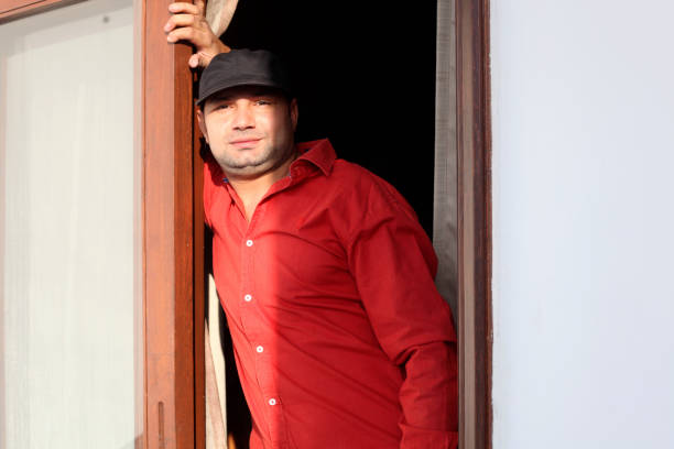 Young men of Indian ethnicity looking out from the hotel window during vacation portrait close up.