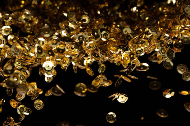 istock Explosion metallic gold glitter sequin sparkle. Golden Glitter sequin spark blink celebrate, blur foil explode in air, fly throw gold particle. Black background isolated, selective focus Blur bokeh 1580355613
