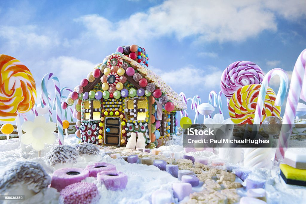 Gingerbread house in christmas landscape Gingerbread house in christmas landscape surrounded by candy canes and sweets Gingerbread House Stock Photo