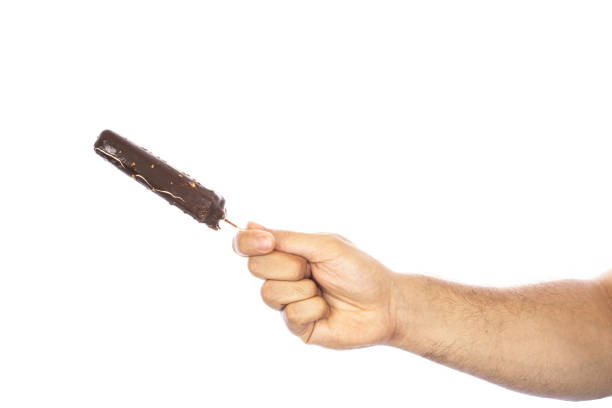 istock Ice cream covered with chocolate and almonds sticks in hand isolated on white background. 1580373161