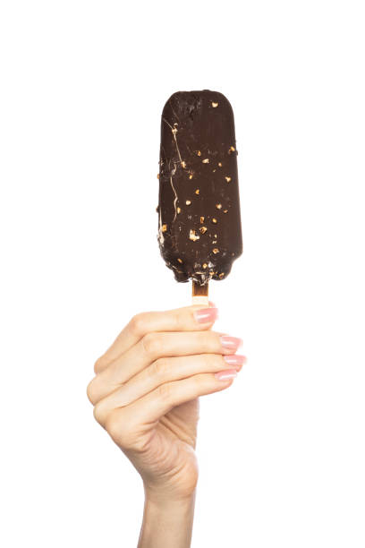 istock Ice cream covered with chocolate and almonds sticks in hand isolated on white background. 1580378440