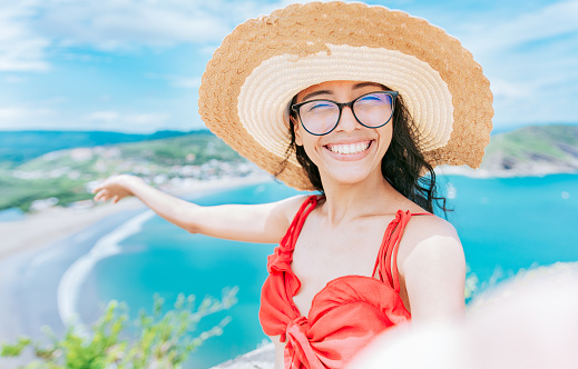 Happy tourist girl taking a selfie on the beach of San Juan del Sur. Concept of woman on vacation taking a selfie on the beach