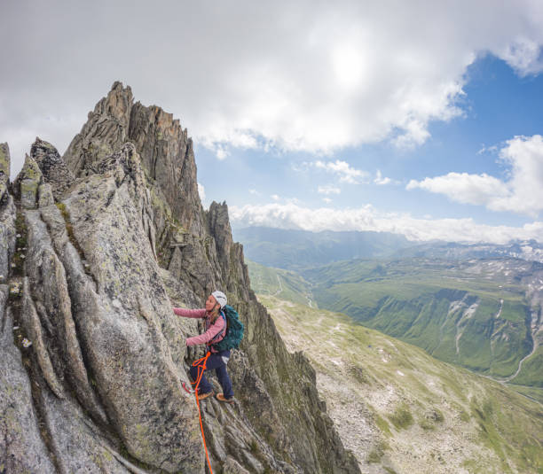 istock Female mountaineer ascending on exposed mountain ridge 1580400636