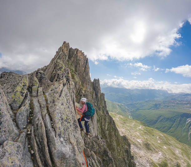 Smiling young woman leading a climbing route in Colorado Spear Head (North Ridge) in Rocky Mountain National Park, Colorado.