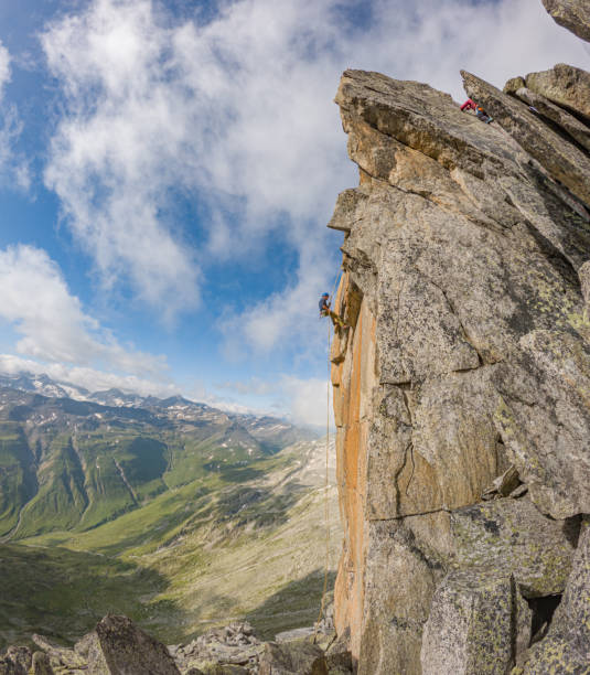 istock Man rappels off cliff in the mountains 1580429600