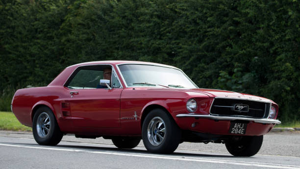Bicester,Oxon,UK - June 19th 2022. Red 1967 Ford Mustang car driving on an English country road