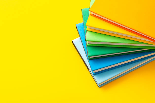 istock Colored text books shot from above on yellow background. Copy space 1580440529