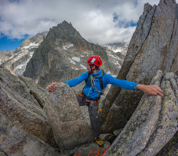 istock Male mountaineer reaches high mountain crest 1580454074