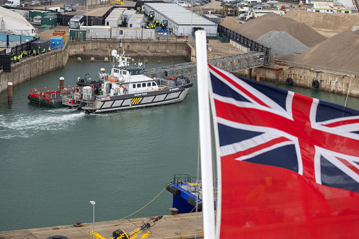 UK Border Force boat moored in Dover harbour as a Union Jack flutters in the foreground