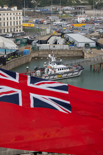 UK Border Force boat moored in Dover harbour as a Union Jack flutters in the foreground