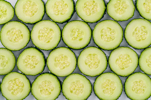 Cucumber slices arrangement in a row composition full frame background summer vegetables