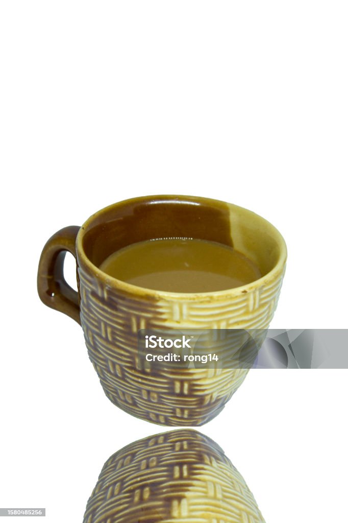 Coffee in a light brown ceramic mug on a white background - background reflections. Caffeinated coffee is popular with people all over the world to consume. Art Stock Photo