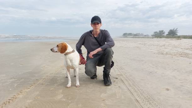 istock man whit dog on the beach 1580485784
