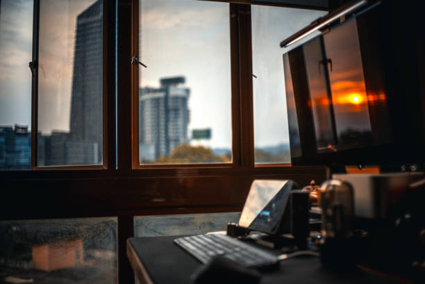istock Sunset looking through window at city with reflection on window with sunset sun 1580567449