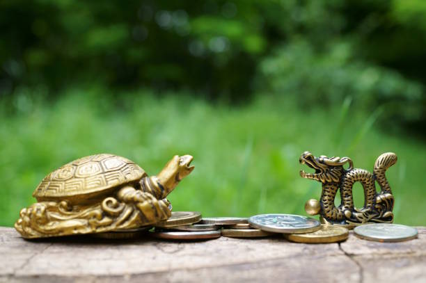 istock Turtle and dragon figurine with coins. 1580574006