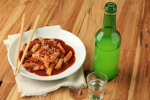 Tteokbokki Korean Rice Cake  with Soju on Wooden Table