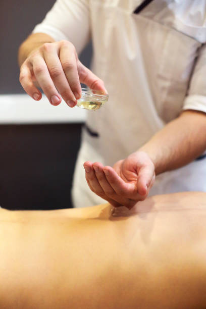istock Crop masseuse using massage oil during skincare procedure 1580667406