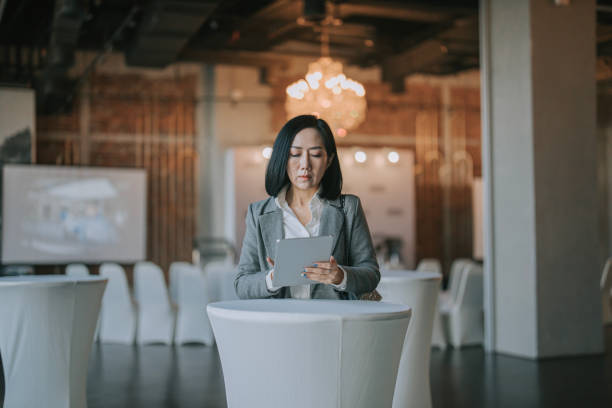 femme d’affaires asiatique utilisant une tablette numérique dans l’espace de réception du séminaire de la conférence d’affaires - conference personal organizer business note pad photos et images de collection
